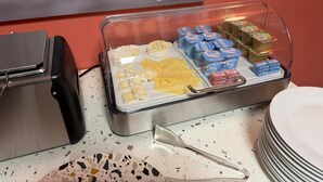 A buffet setup with various cheeses, yogurt, and other dairy products. - Hotel du Village (Village-Neuf)