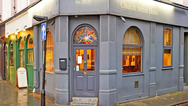 A corner building with a sign reading "Church Street Hotel" and a door with a colorful stained glass window.