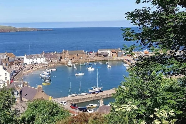 Une ville côtière dotée d’un port de plaisance, de bâtiments et offrant une vue dégagée sur la mer.