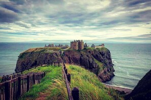 Un castillo costero en un acantilado con vista al mar.