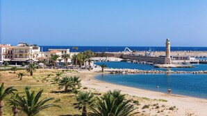 A coastal town with a lighthouse, beach, and marina.