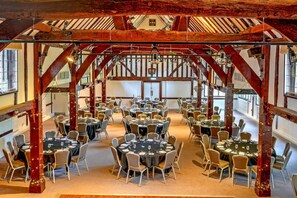 A large hall with multiple round tables and chairs, wooden beams, and a high ceiling. - Sunday Box Hill Burford Bridge - Standard Double Room (Dorking)