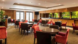 A hotel lobby with a bar area, seating arrangements, and a brick wall. - Sunday Walton Hall Retreat & Spa | Standard Double (Wellesbourne Hastings)