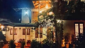 A traditional building with a covered patio, wooden furniture, and potted plants. - The Heritage Inn  (Kandy)