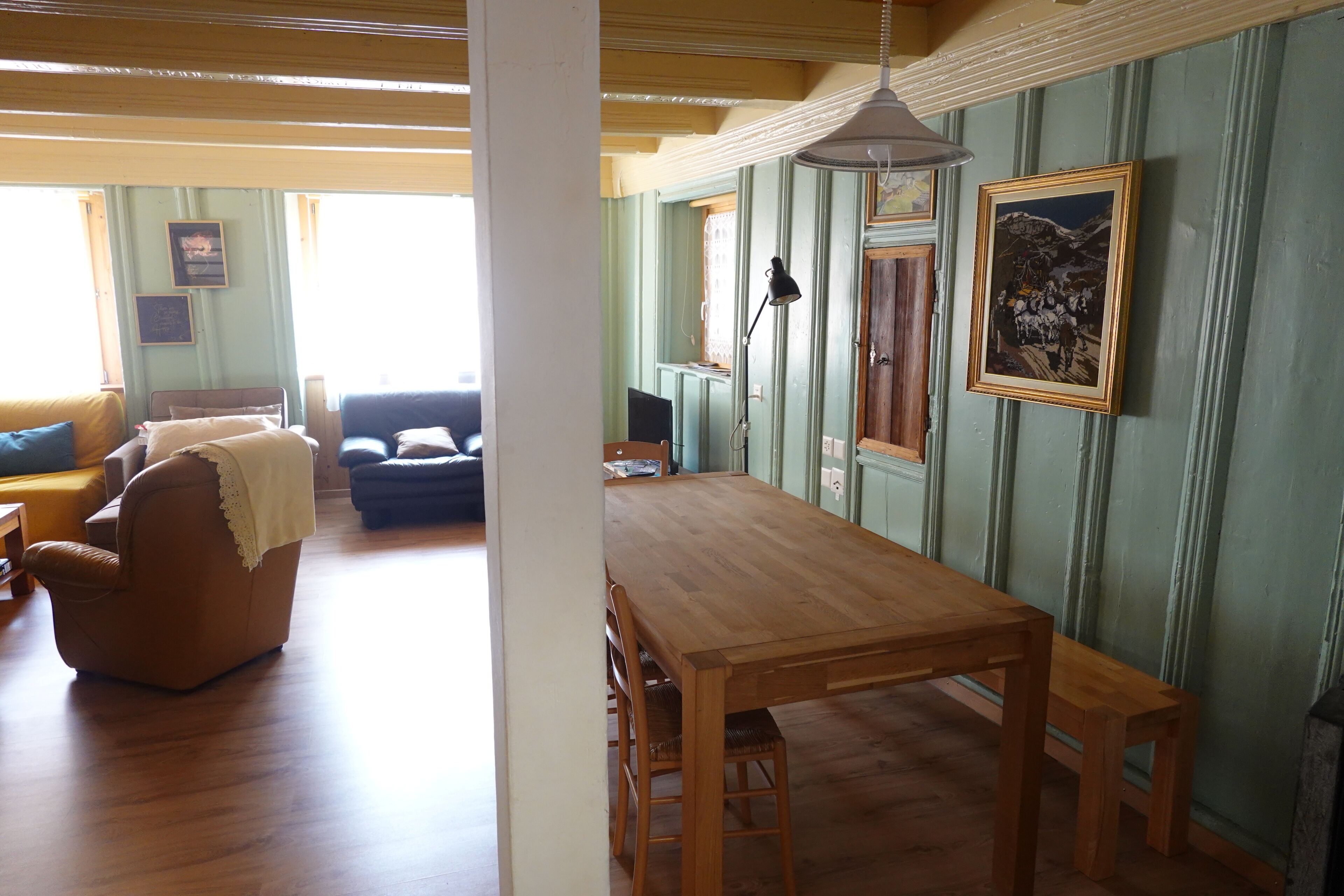 Una habitación con una mesa de comedor de madera, un sofá y una silla.