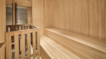 A sauna with wooden benches and a glass-enclosed area with benches.