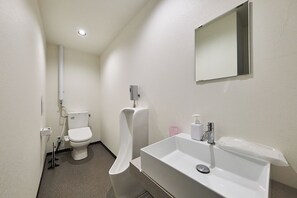 A modern bathroom with a toilet, urinal, and sink. - ASOBIBA Yoichi Onsenside (Yoichi)