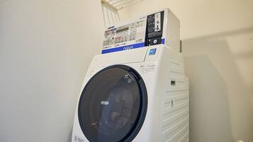 A front-loading white washing machine with a control panel and a circular door.