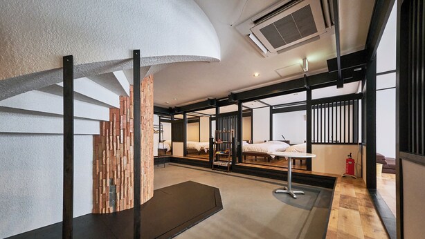 A modern hotel room with a large bed, a desk, and a view through a glass partition. - ASOBIBA Yoichi Onsenside (Yoichi)