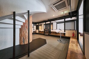 Una habitación de hotel moderna con una cama grande, un escritorio y vistas a través de un panel de vidrio.