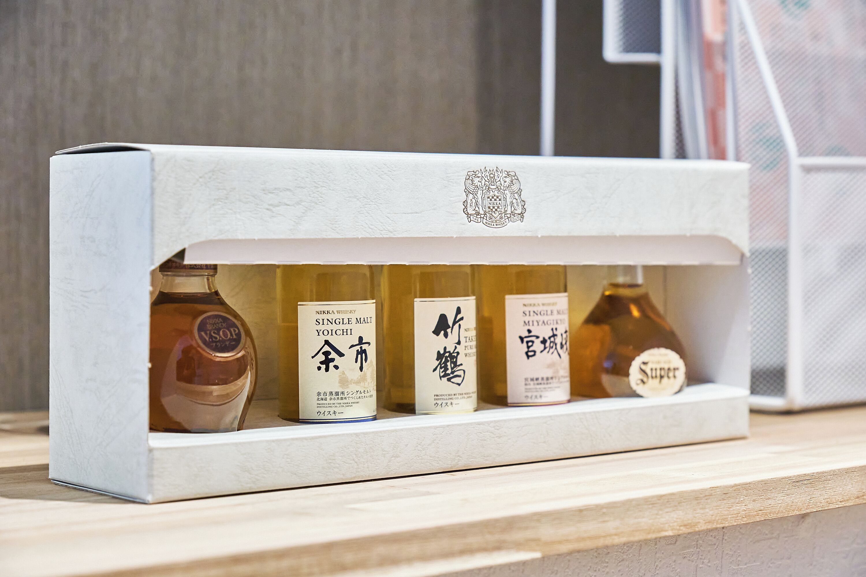 A display of four bottles of whisky on a shelf.