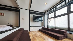 A modern room with a bed, a sofa, a TV, and large windows. - ASOBIBA Yoichi Onsenside (Yoichi)