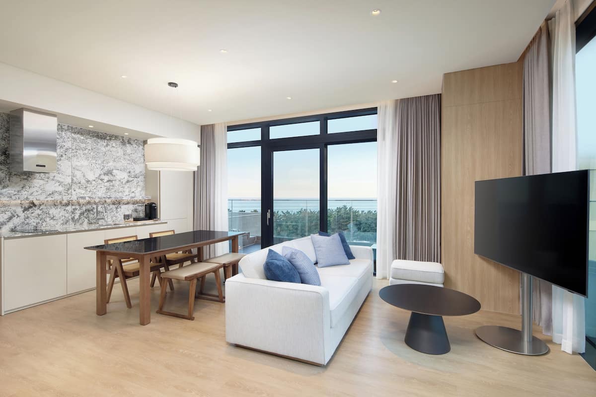 Ein modernes Wohnzimmer mit Esstisch, Sofa und Fernseher.