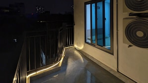 Un balcon doté d’une porte vitrée, de climatiseurs et d’une rambarde.