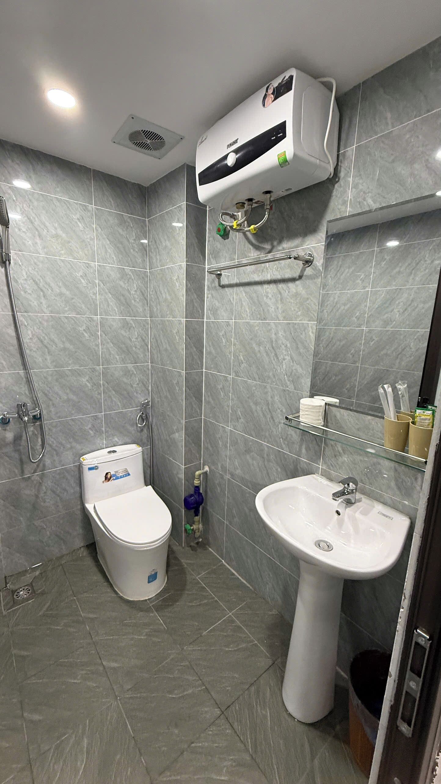 Een moderne badkamer met toilet, wastafel en douche.