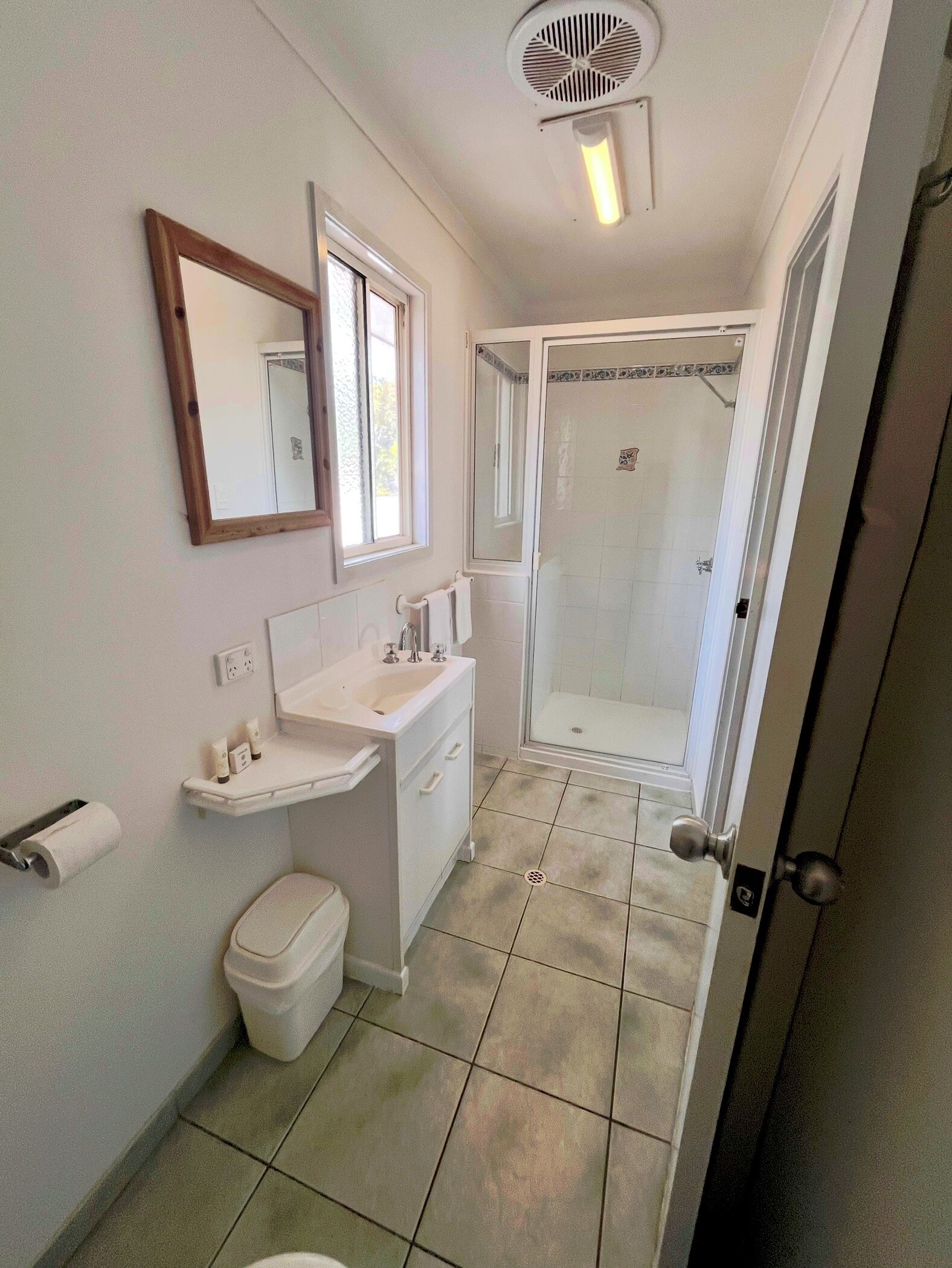 Ein Badezimmer mit Waschbecken, Spiegel, Toilette und Dusche.