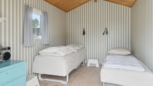 A room with two beds, a radio, a small stool, and a window with curtains. - Lovely cottage in peaceful surroundings (Vejby)
