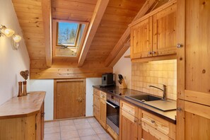 A kitchen with wooden cabinets, a built-in oven, a sink, and a skylight.