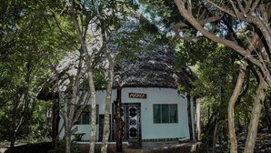 A white building with a thatched roof, surrounded by trees. - one bedroom 8 min to the beach (Diani Beach)