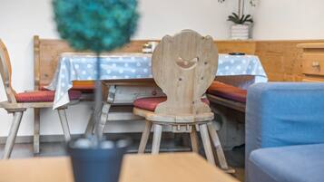 Ein Essbereich mit Holzkästen, einem Tisch mit bunt gepunktetem Tuch und einer Zierpflanze.