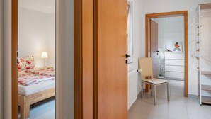 Ein Schlafzimmer mit Bett, Stuhl, Schreibtisch und Heizkörper.
