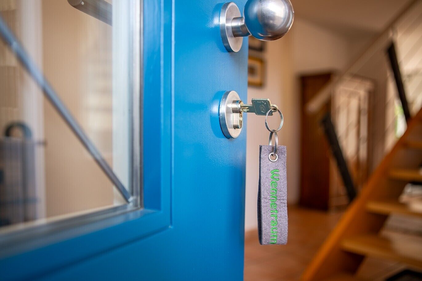 A blue door with a keychain and a keyhole.