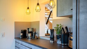 A modern kitchen with a coffee machine, a plant, and hanging lights. - Holiday Home 'Wennetraum' with Sauna, Terrace, and Garden (All for Private Use!) (Eslohe)