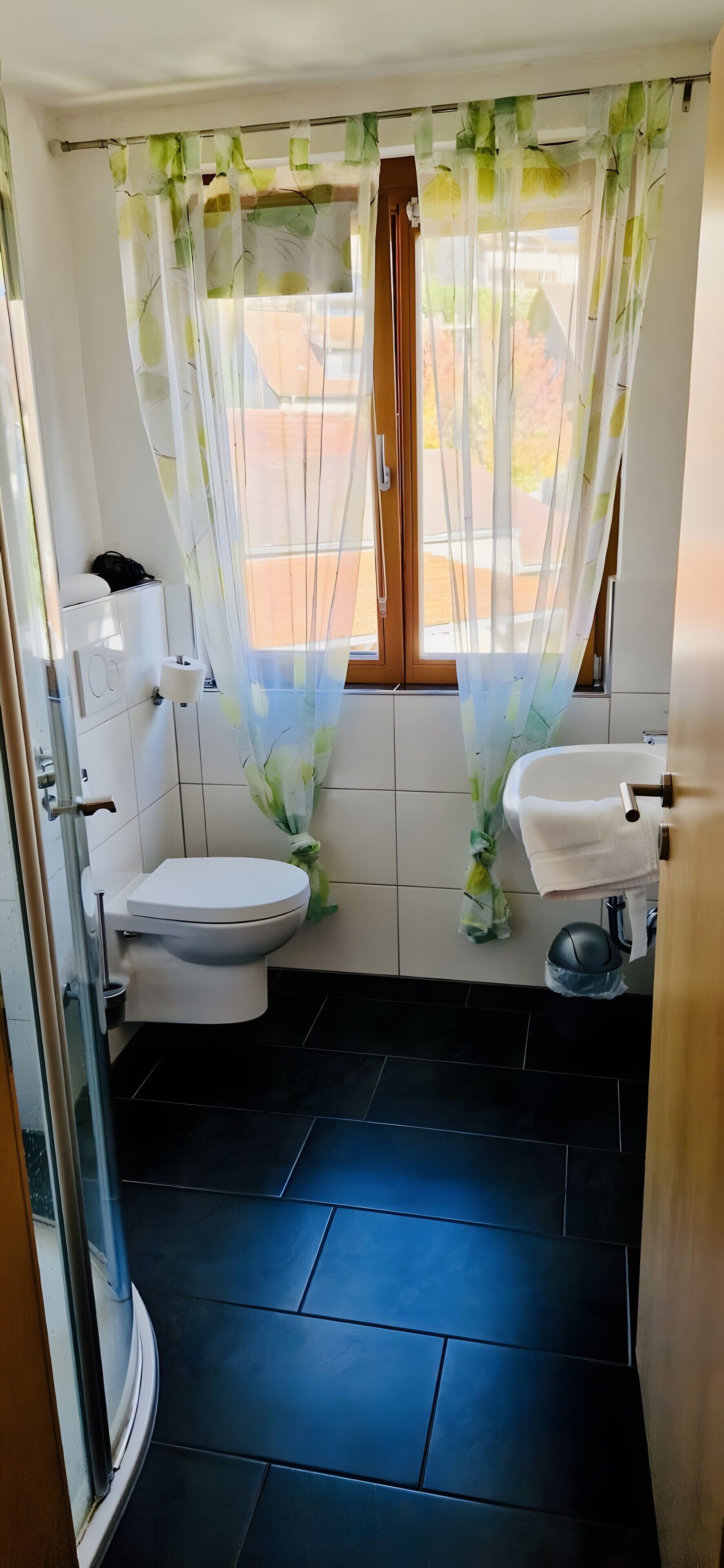 Une salle de bain comprenant des toilettes, un lavabo et un espace douche.