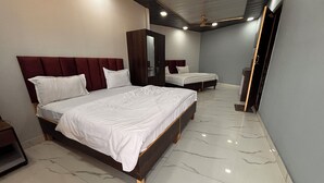 A hotel room with two beds, a wardrobe, and a ceiling fan. - Dharohar Homestay (Rishikesh)