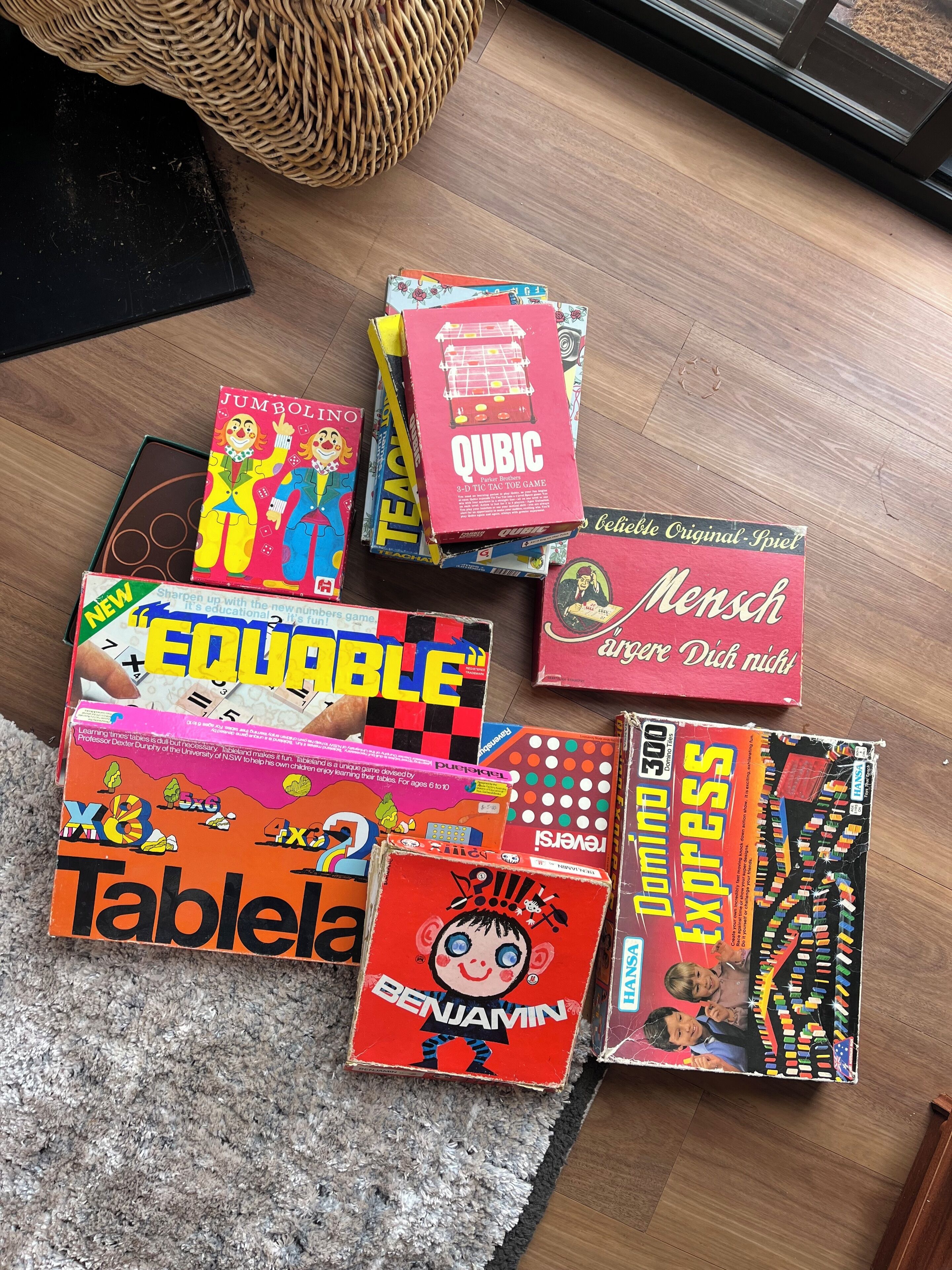A variety of board games on a wooden floor.