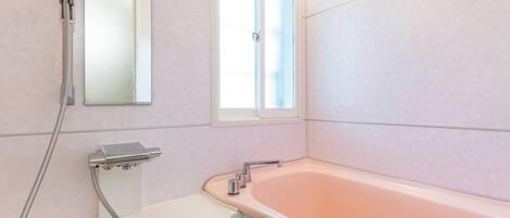 A bathroom with a shower, a sink, a window, and a bathtub.