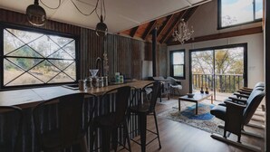 A spacious kitchen with large windows, a bar area, and a seating area with a view of the outdoors. - Secluded rustic 3-bedroom cabin on private land (Dunlap)