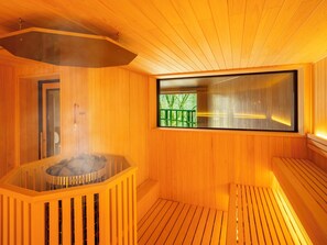 Uma sala de sauna com paredes de madeira e uma janela grande.