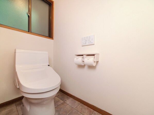 A white toilet with a paper towel holder on the wall. - Wan Wan Paradise Azumino (Azumino)