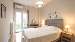 A bedroom with a bed, bedside tables, a mirror, and a ceiling light. - "Urban Comfort Stay" (Athina)