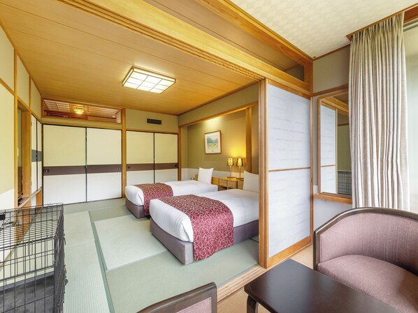 Une chambre d’hôtel de style japonais traditionnel, dotée de deux lits, d’un sol recouvert de tatamis, d’un plafond en bois et d’une porte coulissante.