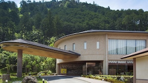 Un edificio moderno con techo curvo y un sendero que conduce a la entrada.