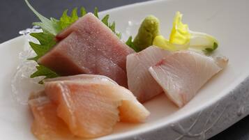 A plate with various sashimi pieces, garnishes, and ice.