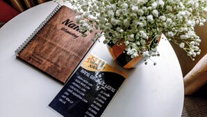 A notebook, a menu, and a potted plant on a table. - Nana House Homestay (Hue)