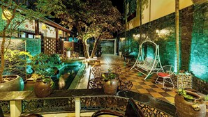A courtyard with a pool, seating areas, and potted plants. - Nana House Homestay (Hue)