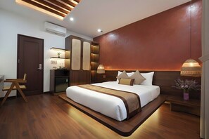 A modern hotel room with a large bed, built-in wardrobe, bedside tables, and a desk area. - Nana House Homestay (Hue)