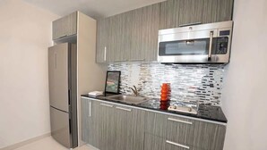 A modern kitchen with a stainless steel refrigerator, a microwave, and a tiled backsplash. - New 1Bedroom Apt. In Condado! C.4 (San Juan)