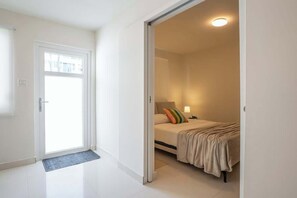 Una stanza con un letto, un comodino e una lampada.