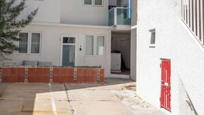 A multi-story residential building with balconies, a gated entrance, and a paved courtyard. - New 1Bedroom Apt. In Condado! C.4 (San Juan)