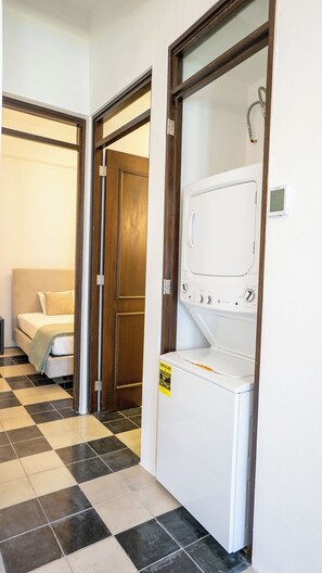 Ein Waschraum mit Waschmaschine, Trockner und einer Wandthermostats.