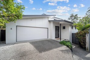 A modern two-story house with a white exterior, a garage, and a driveway.