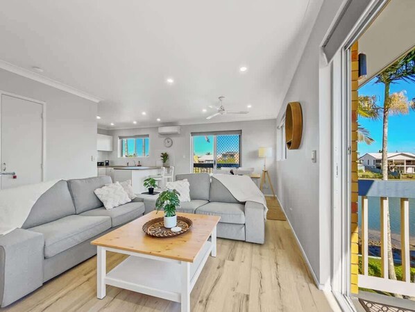 Un salon moderne avec un canapé, une table basse et une vue sur l’extérieur.
