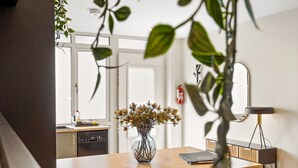 Una cocina con encimera de madera, un jarrón con flores secas, un extintor y una lámpara moderna.