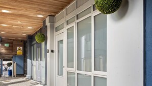 Un pasillo con techo de madera, ventanas de marco blanco y pared azul.