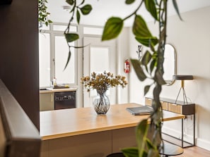 A modern kitchen with a wooden countertop, a vase with flowers, and a kitchen island with a lamp. - Town Centre Studio Clifden (Clifden)
